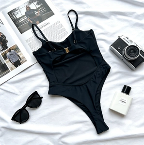 Detailed back view of black one-piece swimsuit with thin straps and gold metal buckle