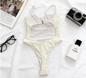 Flat lay of cream one-piece swimsuit with adjustable straps and metal back clasp