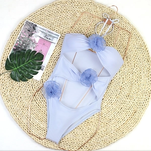 Close-up of lavender one-piece swimsuit with 3D floral accents and cutout details
