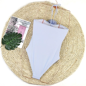 Detail of lavender one-piece swimsuit with 3D floral accent on rose gold hanger