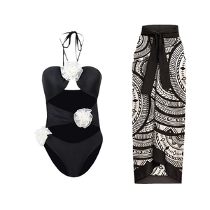 Women's black cutout one-piece swimsuit with 3D white flowers and bohemian wrap skirt
