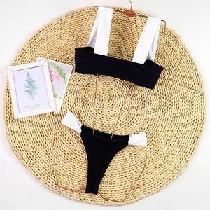 Detail of sexy black and white color block bikini set on a rose gold metal hanger