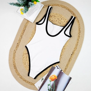 Detail of minimalist black and white ribbed swimsuit with elegant button accents