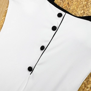 Detail of white ribbed swimwear fabric featuring decorative black buttons and trim