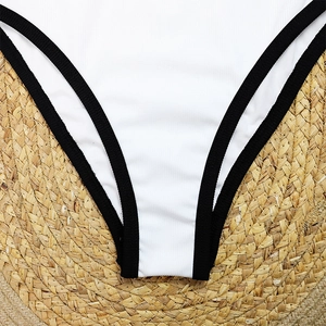 Detail of ribbed texture and black contrast piping on white one-piece swimsuit