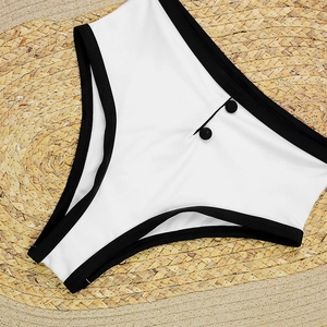 Detail of high waisted bikini bottom featuring white ribbed fabric and black piping