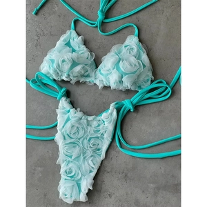 Mint green two-piece bikini featuring 3D floral rosettes and halter neck triangle top