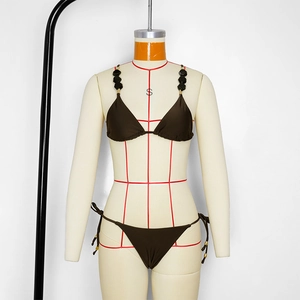 Detail of dark brown bikini top with black geometric beads and textured fabric
