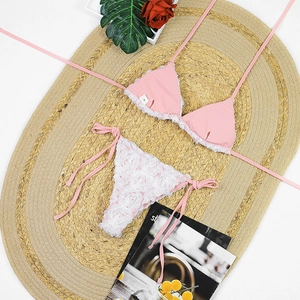 Detailed view of 3D rose floral appliques on pink bikini bottoms with white lace trim