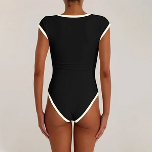Detail of black ribbed bodysuit with white contrast binding on sleeves and high-cut back