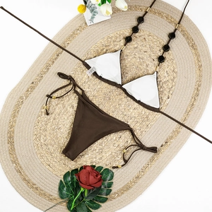 Detail of dark brown bikini top with hexagonal black beads and golden metallic rings