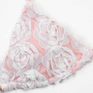 Detailed close-up of pink bikini top with white 3D lace floral petal embroidery