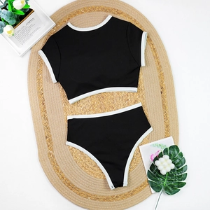 Detailed top view of black and white contrast bikini set on a straw mat background