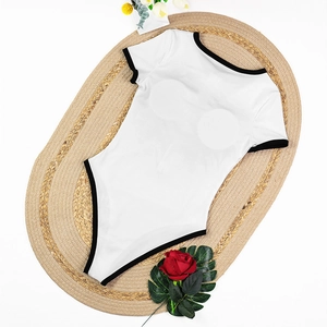 Detailed flat lay of a black and white one-piece bodysuit with ribbed texture on a straw mat