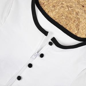 Close-up of white ribbed fabric with black contrast trim and functional zipper detail