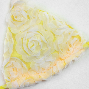 Close-up of 3D white rose floral lace with yellow mesh lining for bikini swimwear