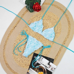Sky blue bikini set featuring 3D rose floral appliques and mesh fabric on flat lay mat
