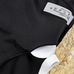 Detail of the white removable pads and M size wash label on a black one-piece swimsuit