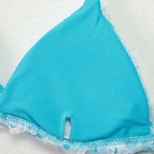 Detail of teal bikini cup with white lace trim and pocket for removable bra pads