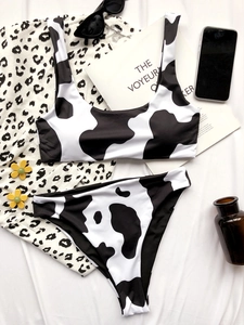 Flat lay of cow print bikini set with sunglasses and summer holiday accessories