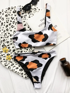 Flat lay of cow print ribbed bikini set with sunglasses and lifestyle accessories