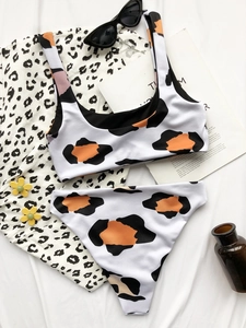 Flat lay of cow print two-piece bikini with ribbed texture and high-waist bottoms