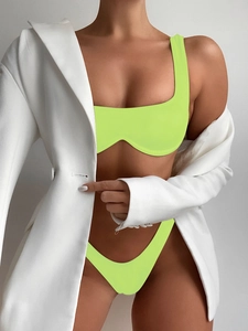 Close-up of vibrant neon green bikini set paired with a white oversized blazer