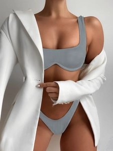 Detail of grey ribbed bikini featuring underwire top and high cut bottoms with a white blazer