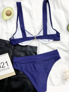 Dettaglio flat lay del bikini blu scuro a due pezzi con ferretto e vita alta