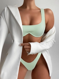 Close-up of mint green ribbed bikini set paired with an oversized white fashion blazer