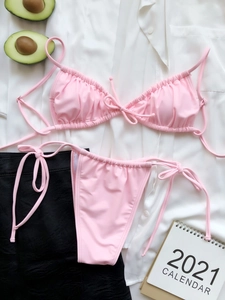 Flat lay detail of pink ruched triangle bikini set with side tie high cut bottoms