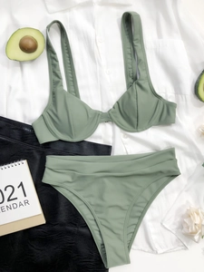 Dettaglio flat lay del bikini a vita alta verde oliva con spalline larghe e tessuto operato