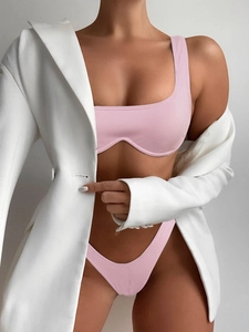 Pink ribbed bikini set featuring square neck top and high-cut bottoms in fashion editorial style