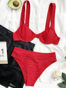 Dettaglio flat lay di un bikini rosso a due pezzi con slip a vita alta e spalline larghe