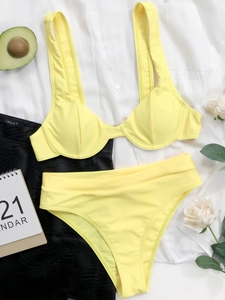Dettaglio flat lay di un bikini a due pezzi giallo brillante con coppe e vita alta