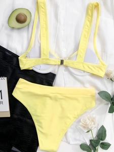 Vista piatta di un bikini a vita alta giallo vibrante con accessori per un look estivo