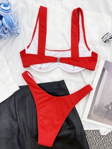 Close-up of red ribbed bikini set with underwire top and high-cut bottoms on white shirt
