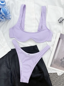 Flat lay of ribbed lilac bikini set with U-neck top and high cut bottoms on neutral props