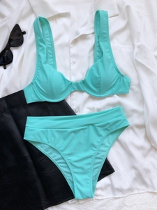 Piatto di un set bikini verde menta con ferretto, occhiali da sole e abiti estivi