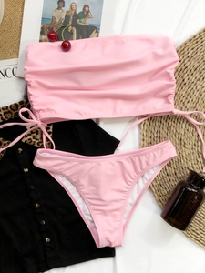 Flat lay of pink strapless bikini top with drawstring details and matching bottoms