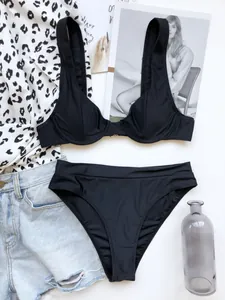 Set bikini nero a vita alta con top con ferretto e accessori estivi alla moda in stile flat lay