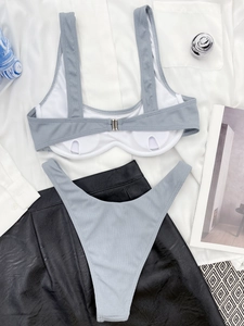 Detailed flat lay of grey ribbed bikini with metal clasp and high-cut bottoms