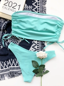 Detailed view of mint green drawstring bandeau bikini set flat lay on a white surface