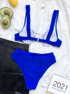 Dettaglio di un bikini blu acceso a due pezzi a vita alta con spalline larghe e fibbia in metallo