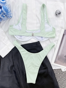 Flat lay of mint green ribbed underwire bikini with metallic buckle and high-cut bottom