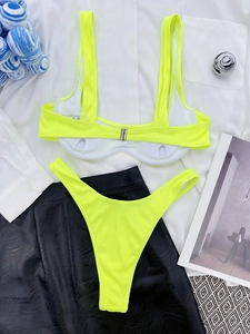 Flat lay of neon yellow ribbed bikini with padded top and high-cut thong on a stylist base