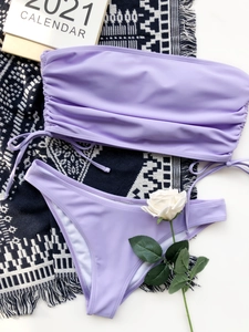 Flat lay of lavender purple drawstring bikini set with a ruching bandeau top and matching bottom