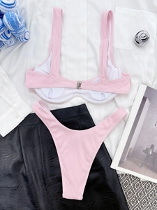 Detailed flat lay of pink ribbed two-piece bikini with metal buckle and V-cut bottom