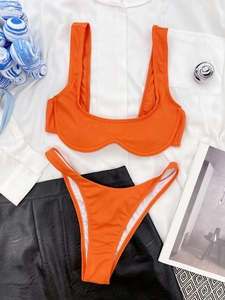Detailed flat lay of bright orange ribbed bikini set with wide straps and high cut bottoms