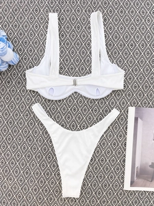 Flat lay of a white ribbed bikini set with metal buckle and textured fabric finish